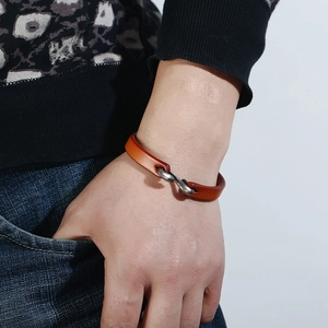 Close-up of vintage brown leather bracelet with metal S-hook clasp on a male wrist