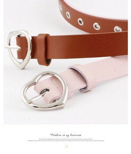 Detail view of brown and pink faux leather belts featuring silver heart-shaped pin buckles