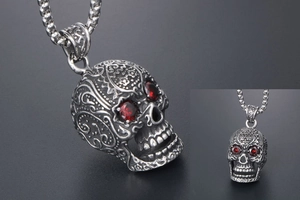 Detailed macro view of punk skull pendant with red gemstone eyes and intricate engravings