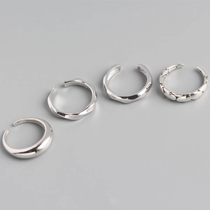 Detail view of four silver S925 rings featuring twisted, faceted, and polished finishes