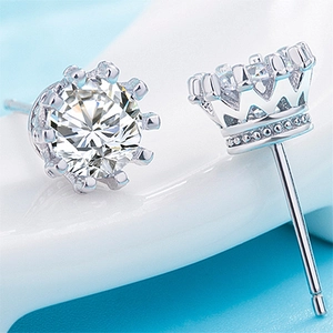 Macro side view showing elegant crown shaped silver stud earrings with sparkling cubic zirconia