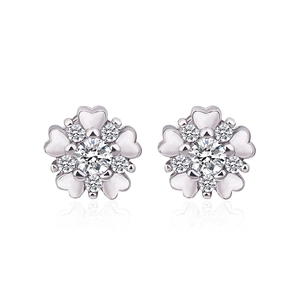 Detailed view of silver flower earrings with white heart petals and sparkling crystals