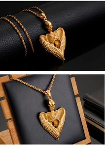 Detail of golden skull wing pendant with amber gemstone on a twisted rope chain
