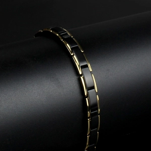 Detail view of men's black ceramic and gold stainless steel link bracelet with magnetic stones