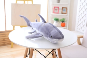 Macro detail of a soft grey shark plush toy with realistic fins and stitched white teeth