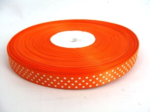 Macro detail of orange ribbon with white polka dots for gift wrapping and DIY crafts