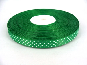 Close-up of green grosgrain ribbon with white polka dots for gift wrapping and DIY crafts