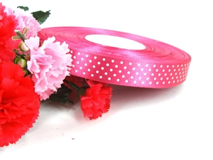 Detailed view of rose red grosgrain ribbon with white polka dots and floral decoration