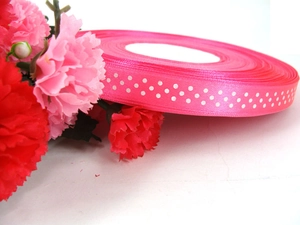 Close-up of pink polka dot grosgrain ribbon with carnation flowers for gift wrapping