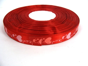 Macro detail of red grosgrain ribbon with white and pink heart pattern for gift wrapping