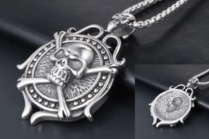 Detail of vintage punk skull and crossbones pendant with ship wheel frame in silver finish