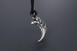 Detailed macro view of retro dragon scale and tiger tooth pendant with metallic texture