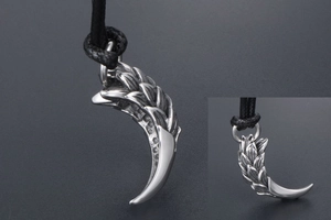 Macro shot of a vintage silver dragon claw pendant with intricate scale textures on cord
