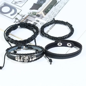 Ensemble de bracelets vintage en cuir tressé avec crâne et perles noires sur fond blanc
