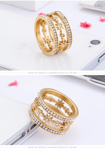 Detail of gold-plated three-layer stainless steel ring with zircon stars and sunburst