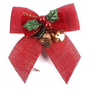 Close-up of red burlap Christmas bow with green velvet leaves and small golden bells