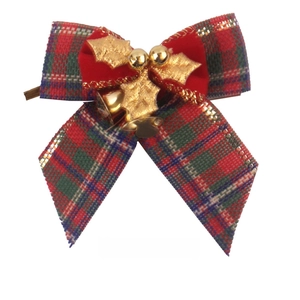 Close-up of Christmas bow with patterned fabric, velvet gold leaves and small bell