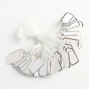 Close-up of bulk white paper jewelry price tags with silver border and cotton strings