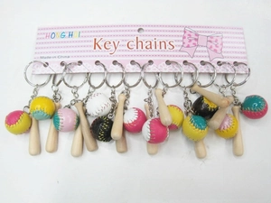 Detail view of mini wooden baseball bat keychains with colorful softball charms on a rack