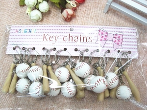 Detailed view of mini baseball bat and ball keychain set on striped card packaging