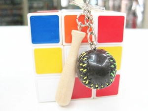Close-up of mini wooden baseball bat keychain with a leather ball and metal ring