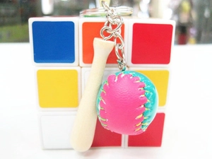 Close-up of mini wood baseball bat keychain with pink and teal leather ball charm