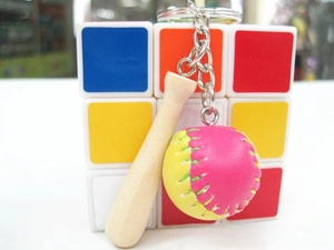 Close-up of wooden baseball bat keychain with pink leather ball and metal ring
