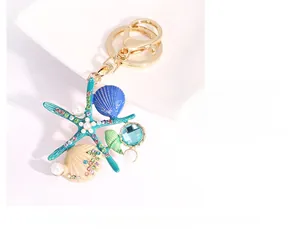 Détail d'un porte-clés étoile de mer avec coquillage bleu, perles et cristaux