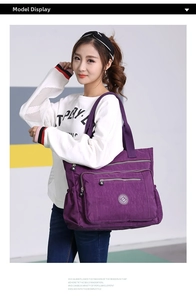 Detailed view of dark purple nylon tote bag featuring multi-pocket design and side drawstring