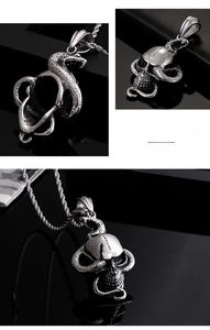 Detail of punk style stainless steel skull and snake pendant with textured scales