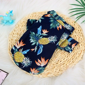 Hawaiian print dog shirt with pineapple and floral patterns on a blue summer pet vest