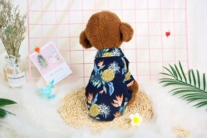 Detail of dark blue Hawaiian dog shirt with vibrant pineapple and leaf tropical print