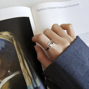 Minimalist S925 sterling silver double-layer ring styled on finger over an art book