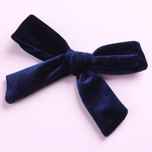 Macro detail of the deep blue velvet fabric texture on a 5-inch handmade bow hair clip
