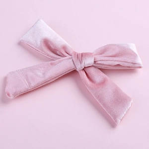 Close-up of a pink velvet bow hair clip with fine texture and silver alligator clip