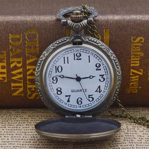 Vintage bronze pocket watch with engraved roman scale and quartz movement on books