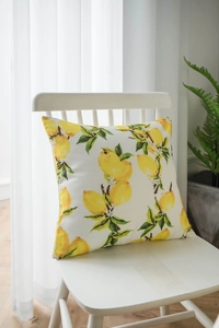Detail shot of a fresh lemon print throw pillow on a white wooden chair by a window
