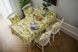 Detail of fresh lemon print tablecloth and matching chair cushions in cotton linen fabric
