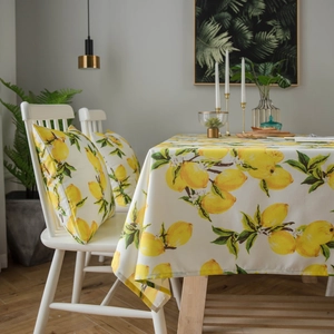 Fresh yellow lemon print waterproof tablecloth and matching pillow on wooden table