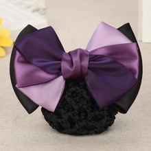 Detail of professional hair clip with purple satin bow and black mesh hairnet