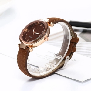 Detailed macro view of a brown starry sky dial with gold case and leather strap quartz watch