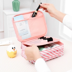 Detail of pink striped cosmetic bag interior showing mesh compartments and storage usage