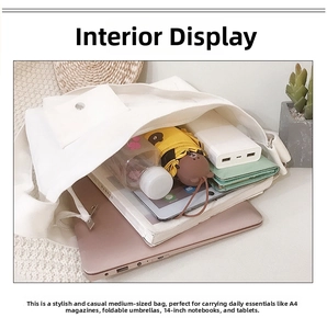 Binnenzicht van een witte canvas tas met ruimte voor een 14 inch laptop en diverse boeken