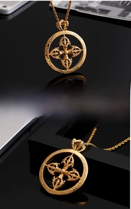Détail macro du pendentif croix gothique en acier inoxydable doré avec chaîne torsadée