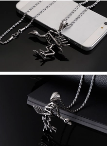 Macro shot of Gothic silver raven skeleton pendant on leather with metallic twist chain