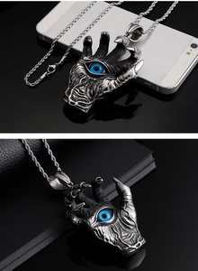 Macro shot of gothic dragon claw pendant with blue eye stone on a vintage silver chain