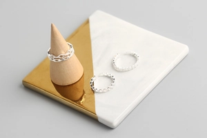 Close-up of S925 sterling silver heart and star ring set on a marble display tray