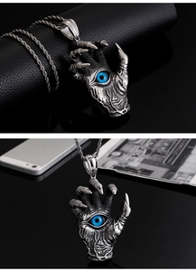 Detailed view of silver dragon claw pendant with blue eye and vintage black texture
