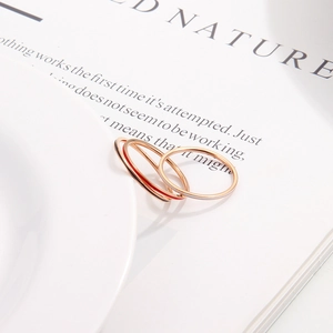 Three minimalist 1mm rose gold and gold stackable thin rings on a white plate