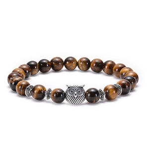 Detail of tiger eye bead bracelet featuring a silver owl charm and vintage metal spacers